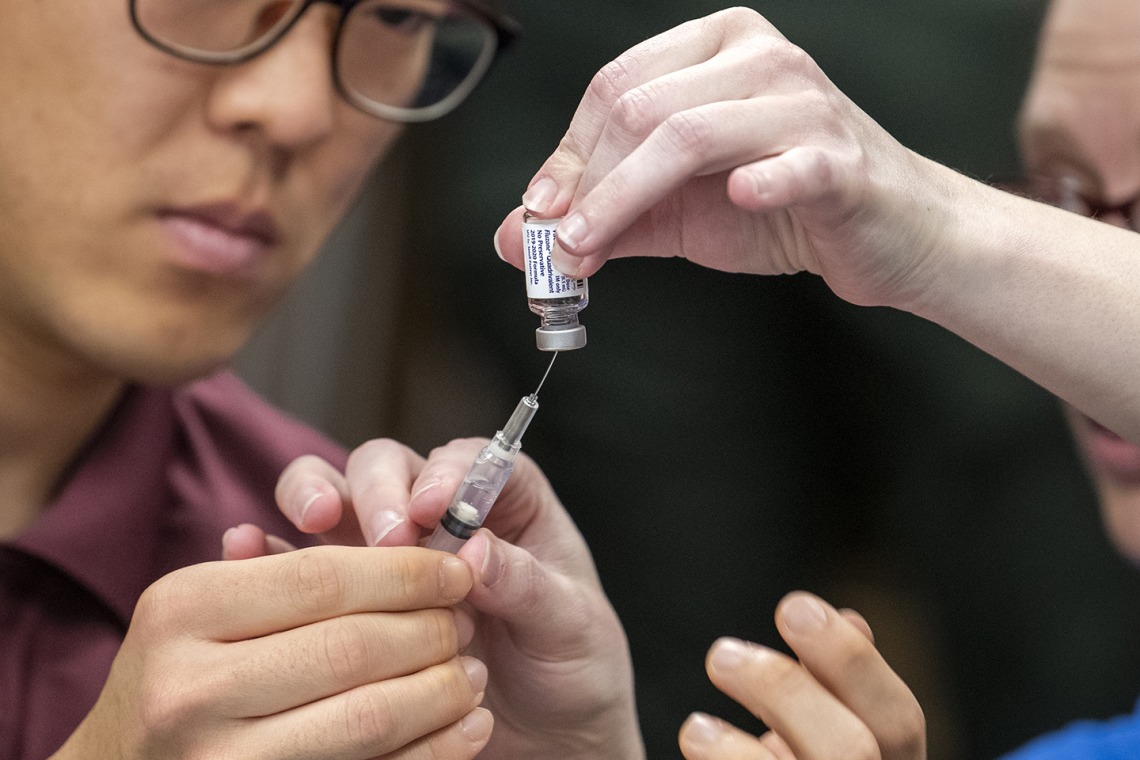 A Street Medicine Phoenix student volunteer prepares to administer a flu vaccine.