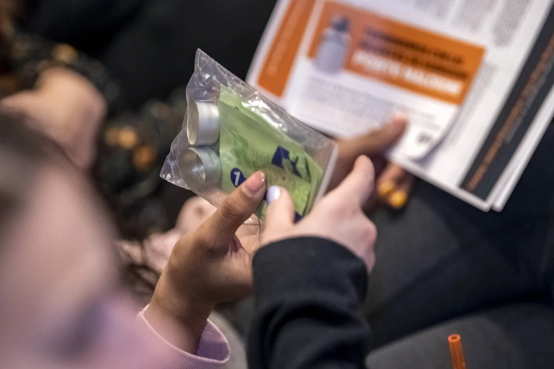 Attendees pass around a Rapid Response testing kit during the Drug Survival 102 panel presentation.