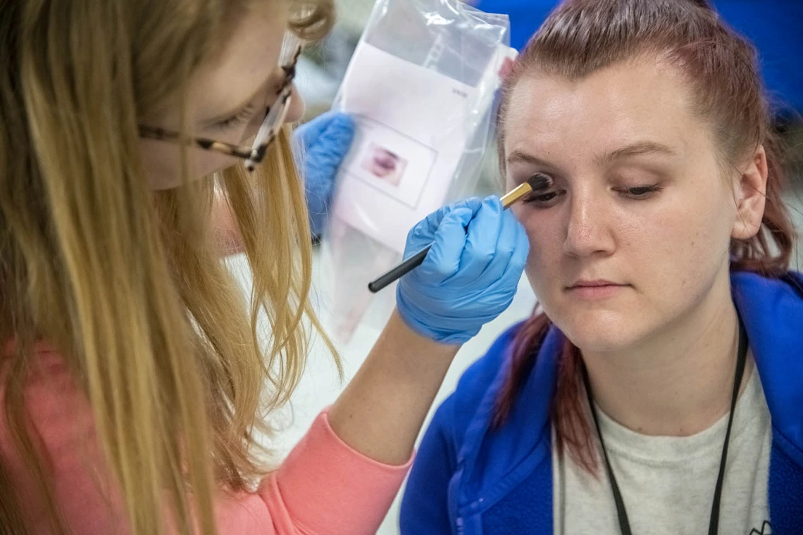 Sadie Keesler, an undergraduate at the University of Arizona College of Science and ASTEC volunteer, spent one morning of her Spring Break applying makeup to TPD volunteers roleplaying injured travelers. Here, Kessler creates a black eye on Tylinn Smith.