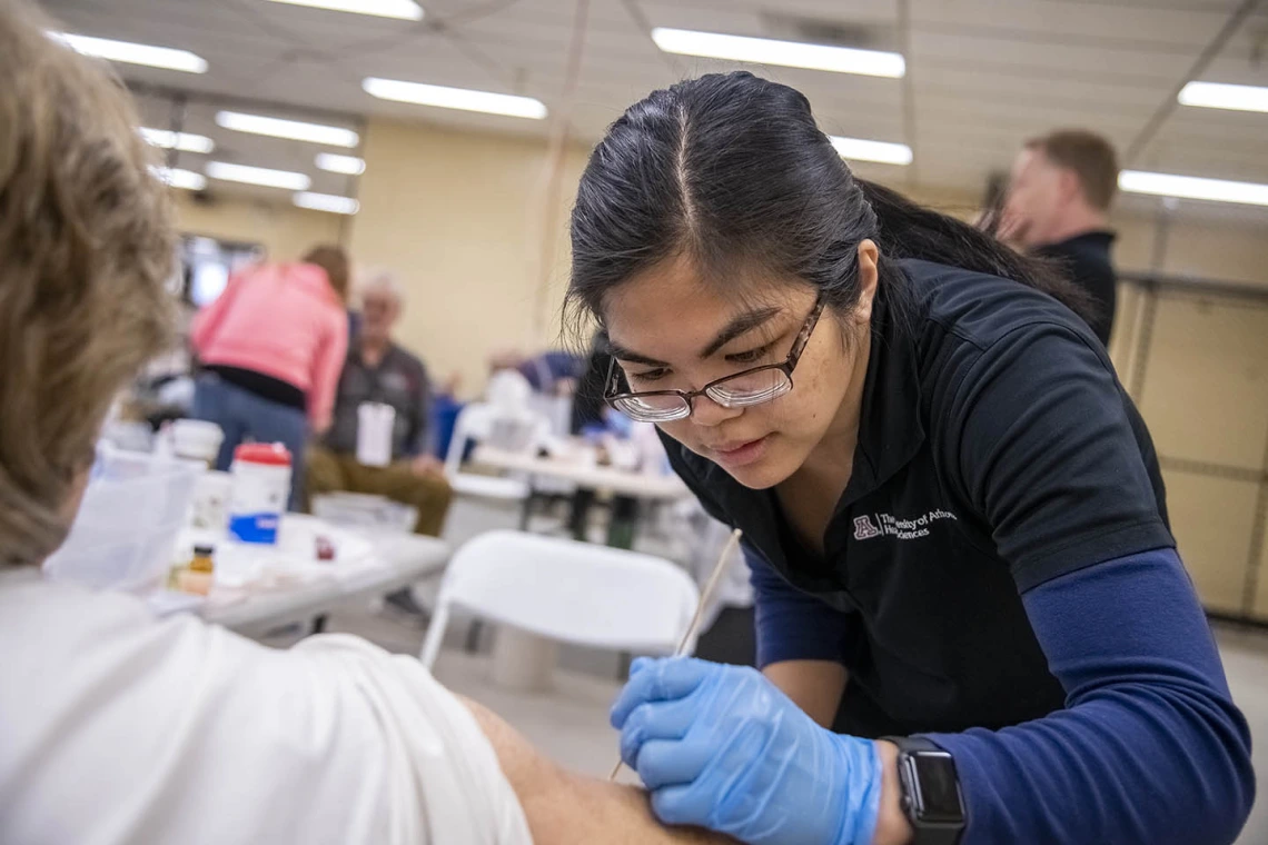 Merryl Lopido, simulation operations specialist for ASTEC, places fake skin on a woman to simulate a wound sustained during a flight. In this scenario, a drone landed on an airplane’s wing and exploded, injuring several passengers and forcing the plane to land.