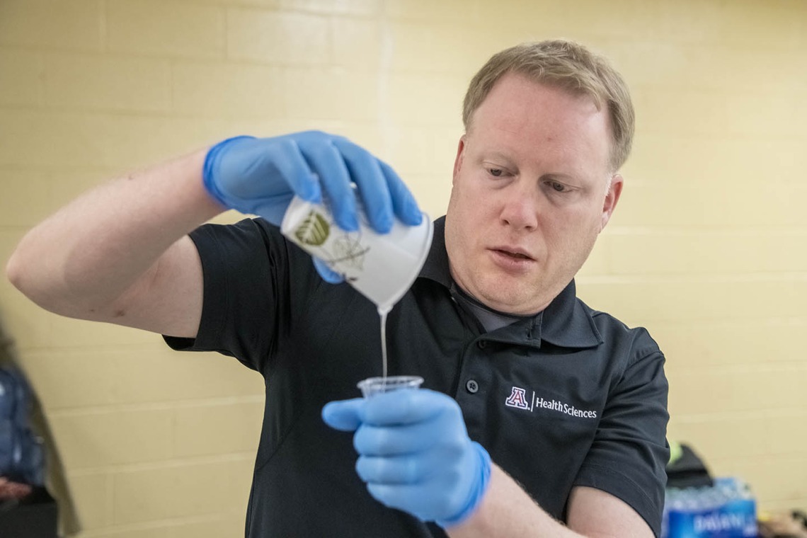 David Biffar, ASTEC’s assistant director of operations, pours liquid latex into a cup to prepare for the creation of the next volunteer’s wound.