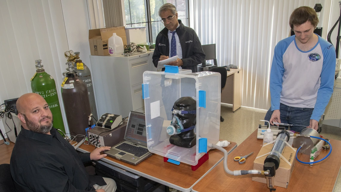 Lab manager Christopher Morton, Sairam Parthasarathy, MD, and engineering graduate student Connor Stahl test face masks in the Center for Sleep and Circadian Sciences.