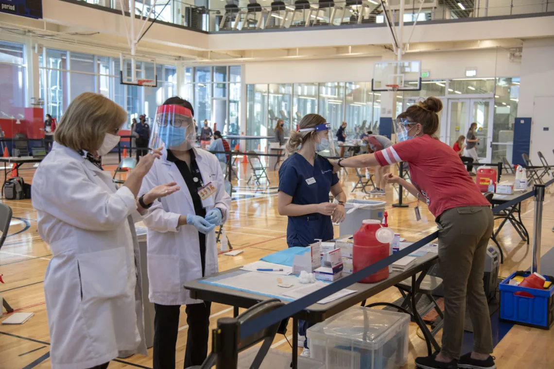 Lisa Davis, PharmD, professor of pharmacy practice and science (left), speaks to PharmD student Lisa Le as College of Nursing student Genevieve Veneziale gets advice from Campus Health nurse Karen Schwartz, RN (right).