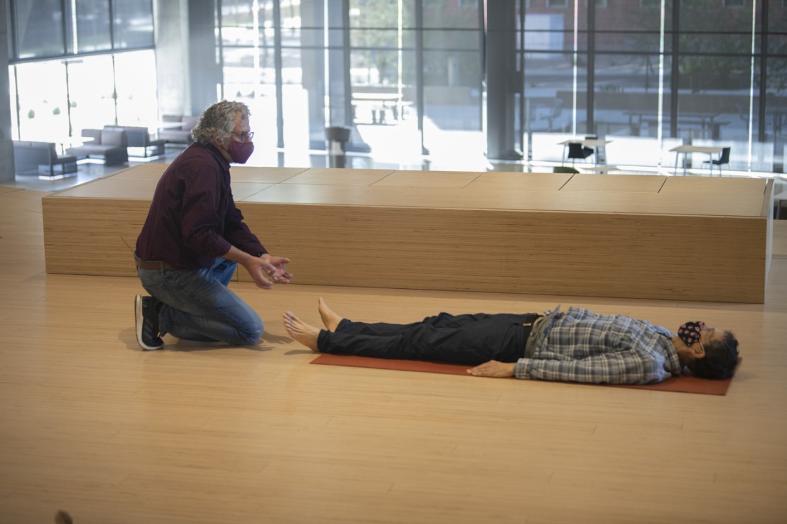 While a participant rests on his back, Andrew Belser demonstrates a technique to promote mindful movement during the second class in the “Aging and the Arts” series.