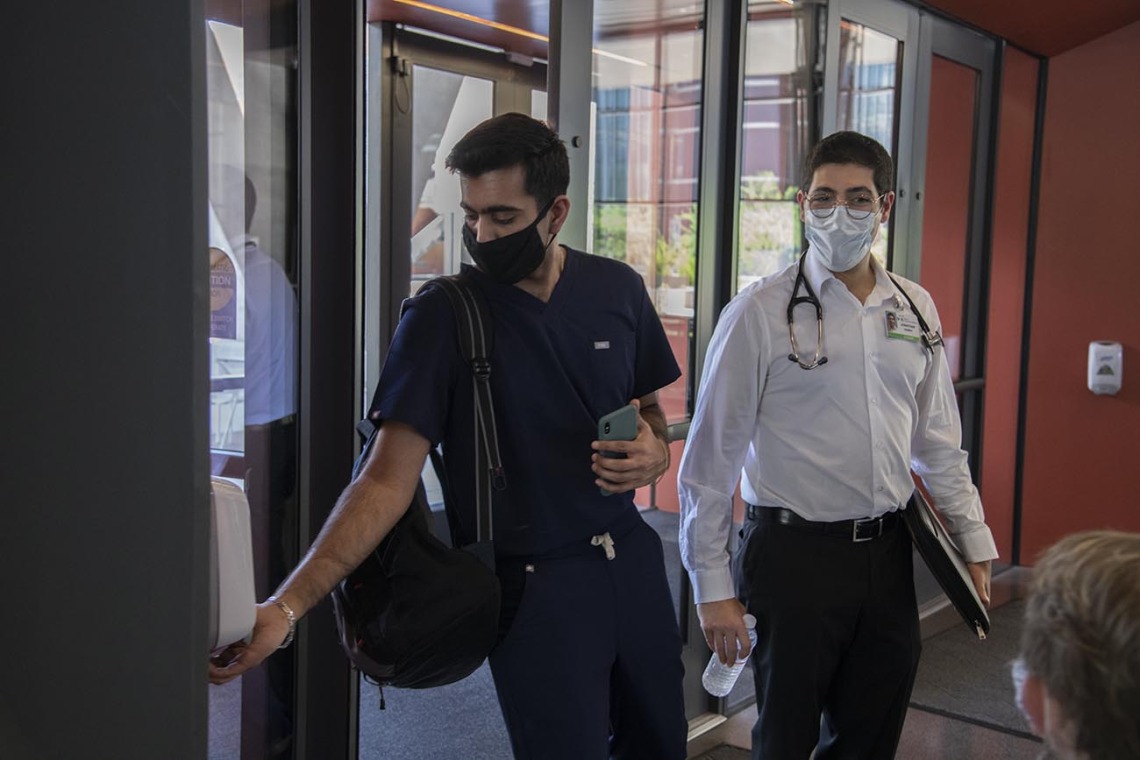 First year College of Medicine – Tucson student Yasi Suri, left, puts sanitizer on his hands before he and fellow first year student Jonathan Yasmeh  head to a class in the Health Science Innovation Building.