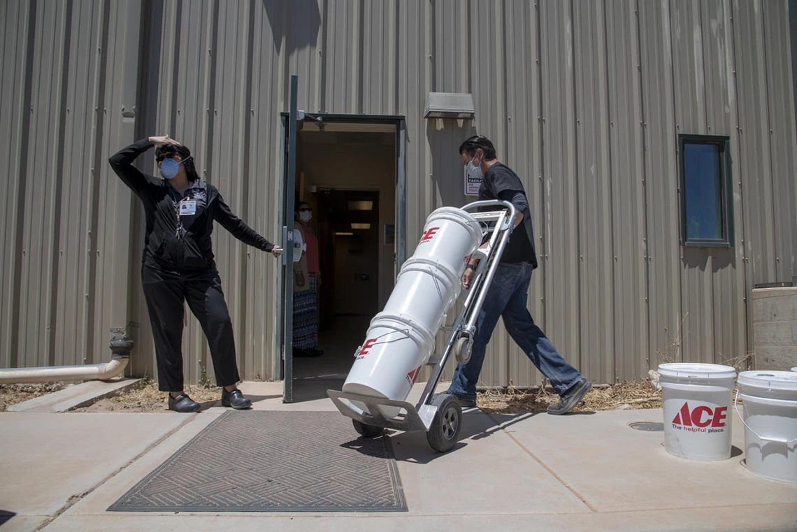 Josh Cliffords moves buckets of sanitizer into the Tuba City Regional Health Care. The sanitizer was donated by University of Arizona College of Medicine – Tucson students.