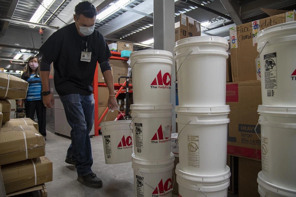 Josh Cliffords carries buckets of sanitizer into a warehouse for Tuba City Regional Health Care. The sanitizer will be distributed to the health center and the community.