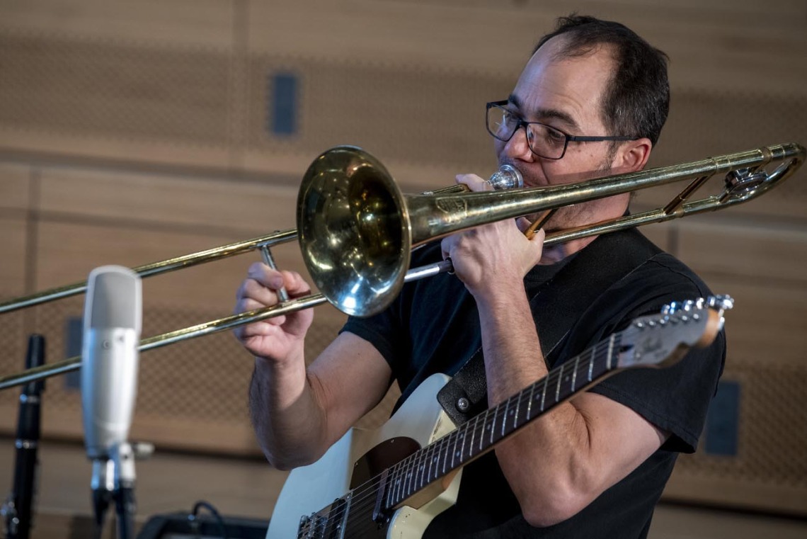 Two-Door Hatchback’s Marco Rosano plays a trombone while filming for The Tucson Studio. Rosano also plays the guitar for the band. 