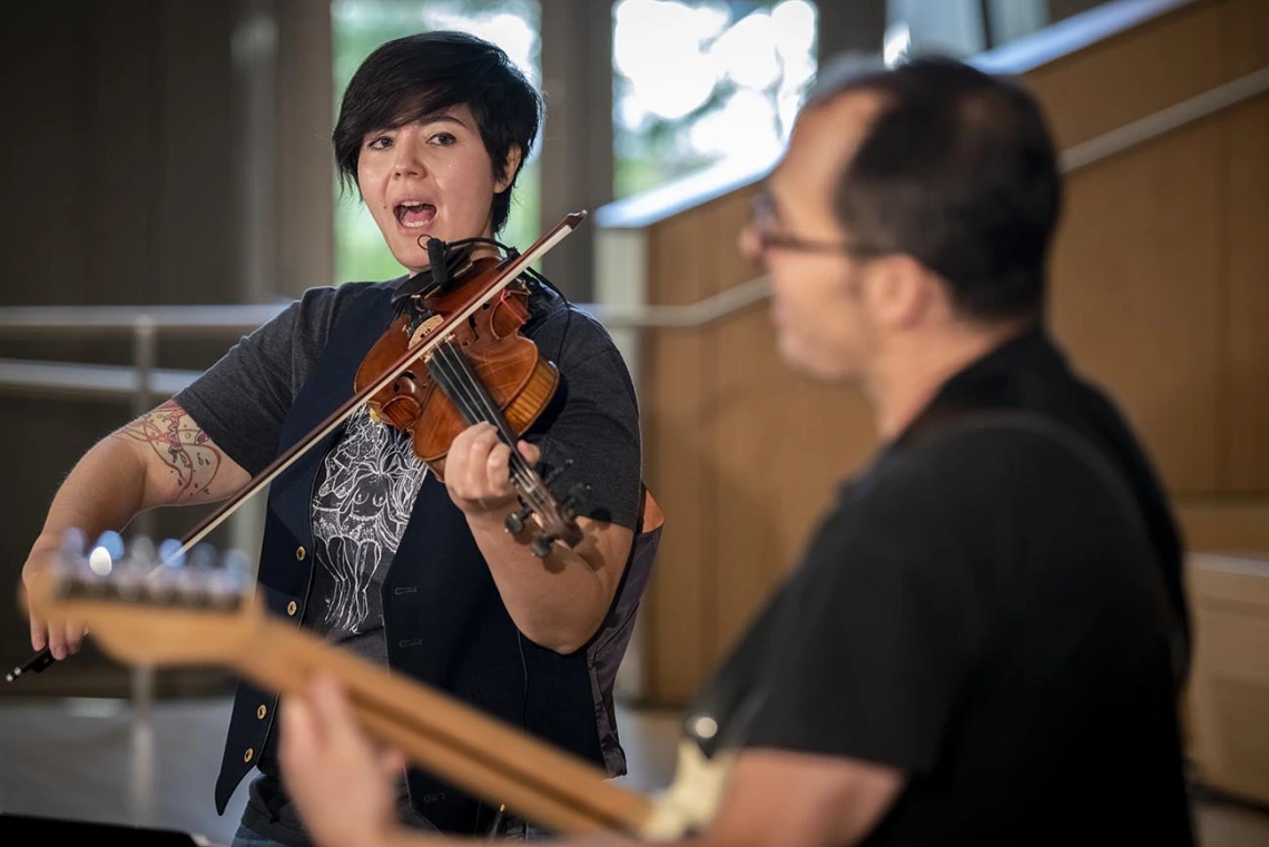 Two-Door Hatchback’s Samantha Bounkeua sings and plays violin in a performance for The Tucson Studio on the Health Sciences campus in Tucson.