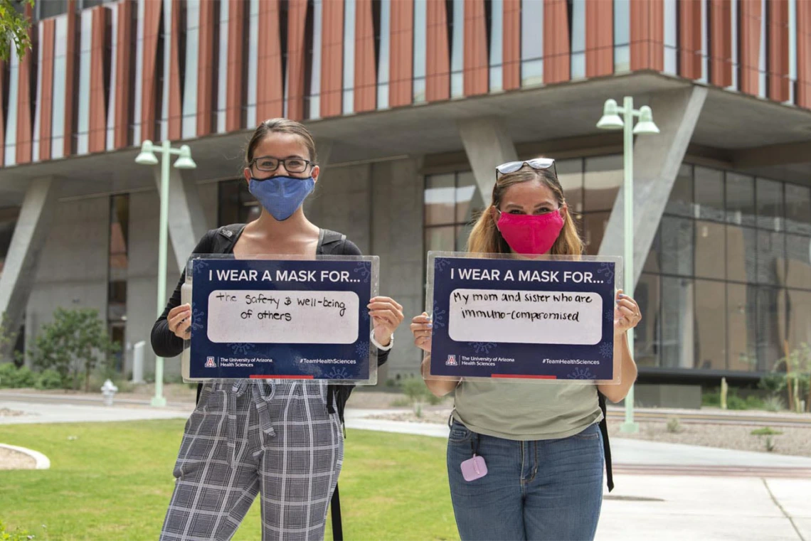 Jacqueline Sanchez  and Alyssa Cordova, College of Medicine – Tucson research technicians, hold their signs in front of the Health Sciences Innovation Building in Tucson. Sanchez and Cordova are graduate students in the Postbaccalaureate Research Education Program at the University of Arizona (PREP@UAZ ), which provides American Indian/Alaskan Native students with a rigorous research and educational foundation to prepare them for biomedical doctorate programs. 