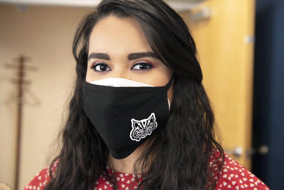 Maryell Martinez, administrative associate for the Mel and Enid Zuckerman College of Public Health’s Phoenix campus, wears a black mask with a wildcat incorporating the man in the maze motif, a sacred symbol of the Tohono O’odham people. 