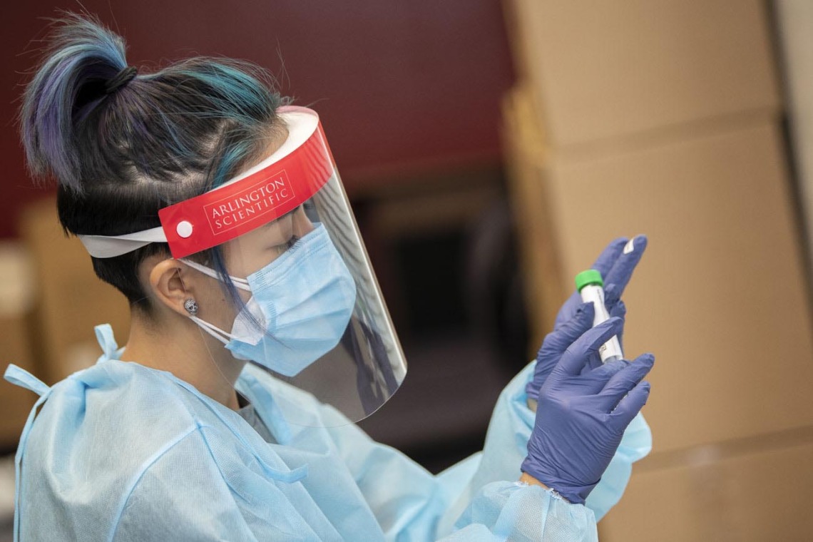 Registered nurse Shannon Espinosa puts a label on a tube for an antigen test at the University of Arizona Phoenix Biomedical Campus.
