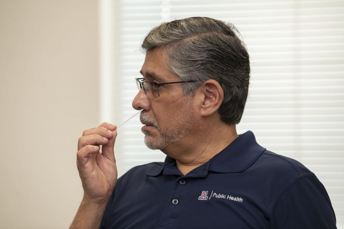 Rodrigo Silva, DVM, MPH, adjunct professor at the Mel & Enid Zuckerman College of Public Health in Phoenix, administers the COVID-19 antigen test by placing a swab inside his nostril to collect a sample. 