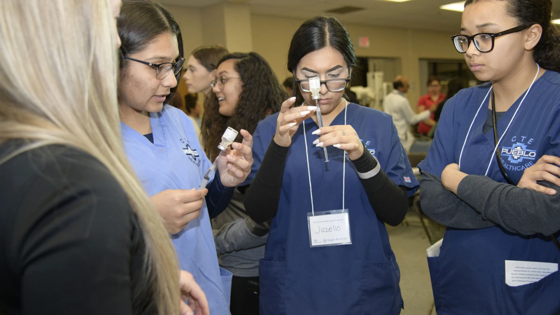 High school students learning about career options in health care visit the nursing booth.