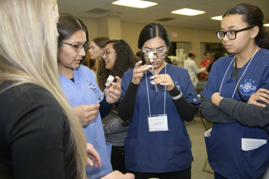 High school students learning about career options in health care visit the nursing booth.