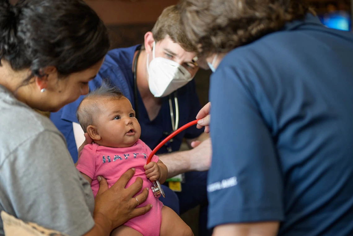 Judith Hunt, MD, and student Jeremy Winkleman win over Anastasia Lopez by letting her be in control of the stethoscope – perhaps she is a medical student in the making. 
