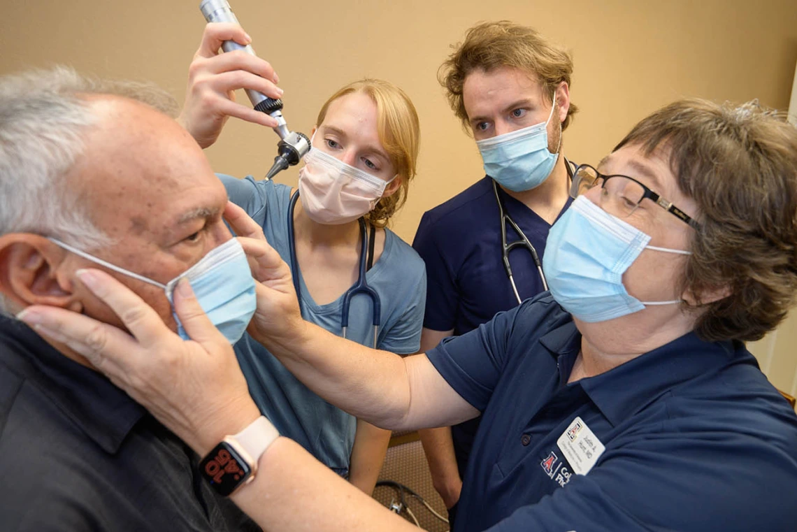 Johnny Waldmann (left) has a mark on his skin examined by resident Lauren Washatka, MD, medical student Colton Cowan and Judith Hunt, MD. 