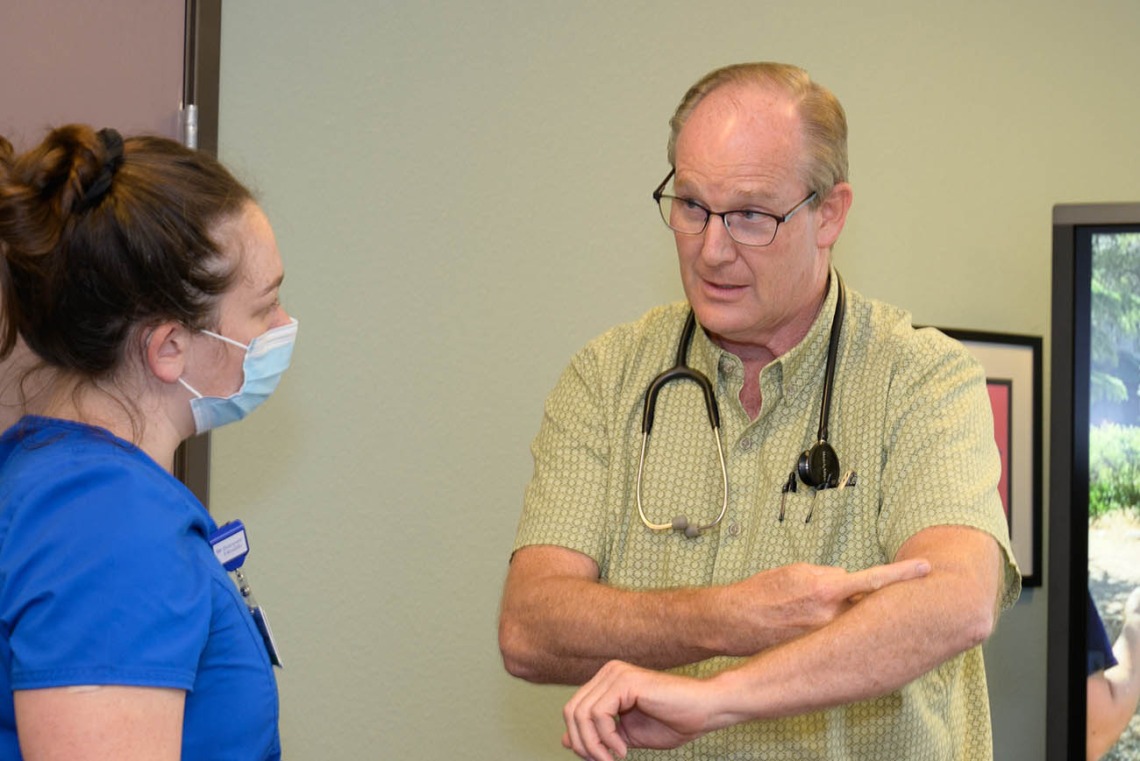 Alan Michaels and Amanda Zauner discuss patient care in the Pondersoa Family Care Rural Clinic run by Judith Hunt, MD, in Payson. 