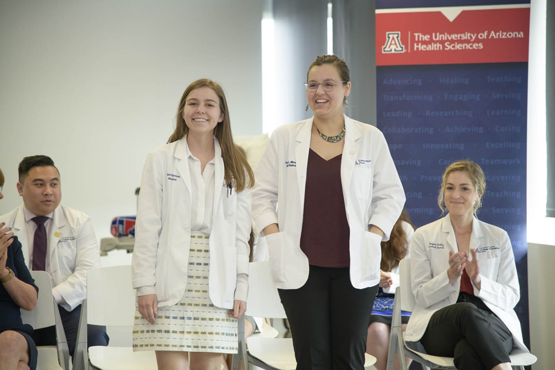 Primary Care Physician scholarship recipients Merrion Dawson and Kathryn Blevins stand as their names are announced during the reception. 