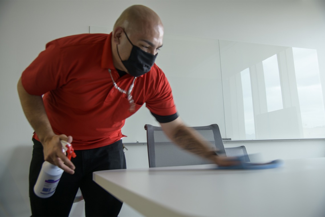 Jose Benitez from University of Arizona Facilities Management cleans a table in the Health Sciences Innovation Building.