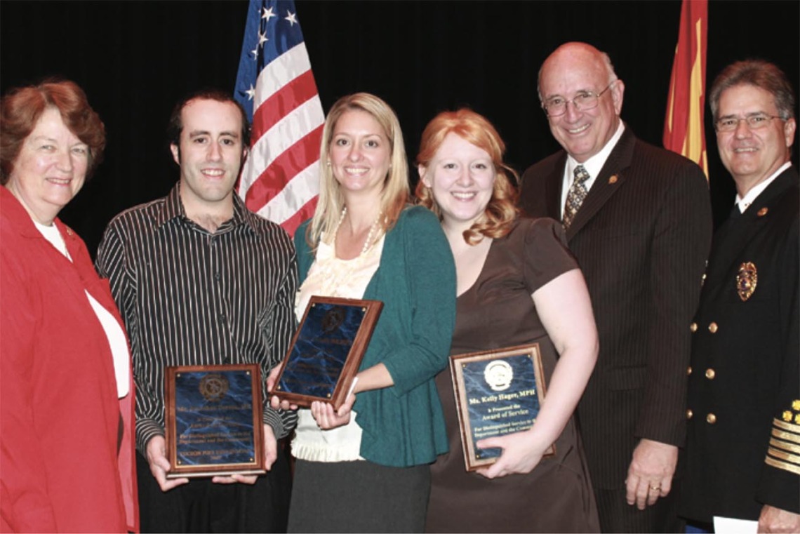 Professor Kelly Reynolds, PhD, MSPH, and two graduate students are presented with the Tucson Fire Department’s Award of Service at a ceremony in the Tucson Convention Center on Feb. 19, 2010. Pictured from left: Tucson City Councilwoman Shirley Scott; Jonathan Sexton, PhD; Dr. Reynolds; student Kelly Hager; Tucson Mayor Bob Walkup; Tucson Fire Chief Patrick Kelly.