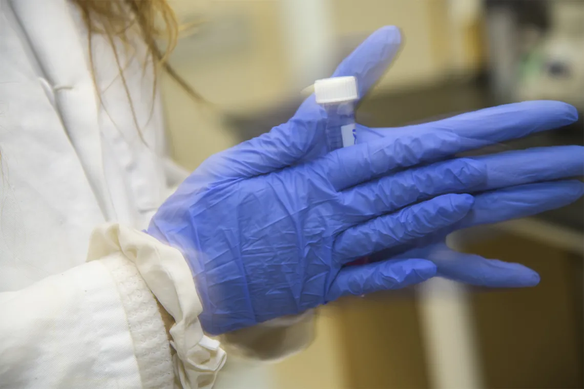 A lab worker shakes up a compound in one of the new College of Pharmacy laboratories being used for drug discovery research.