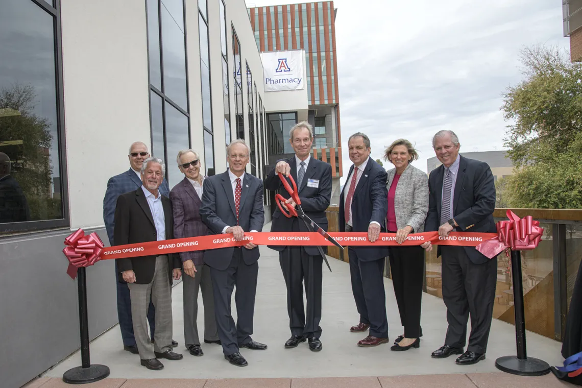 Ribbon cutting for the renovated and expanded Skaggs Center, from left to right: University of Arizona Foundation President and CEO JP Roczniak; donor Richard Katz; donor Ken Coit; UArizona College of Pharmacy Dean Rick Schnellmann, PhD; Ronny Cutshall, president of The ALSAM Foundation, which was established by the Skaggs family; UArizona Senior Vice President for Health Sciences Michael D. Dake, MD; UArizona Provost Liesl Folks, PhD, MBA; UArizona President Robert C. Robbins, MD.