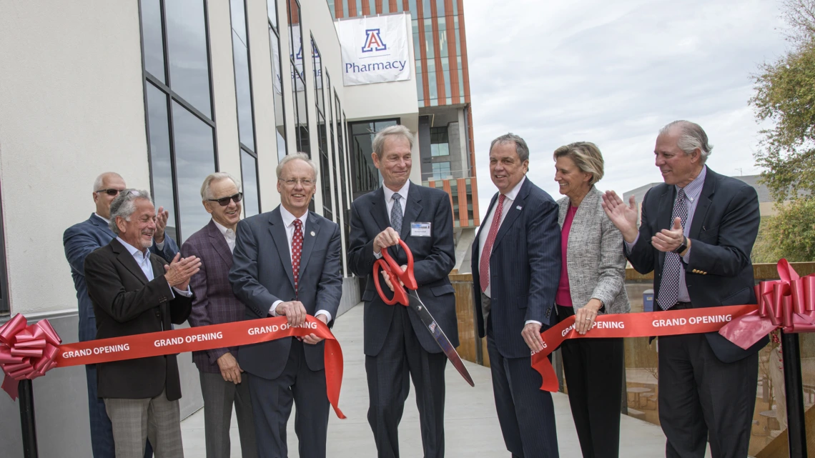 Ribbon cutting for the renovated and expanded Skaggs Center, from left to right: University of Arizona Foundation President and CEO JP Roczniak; donor Richard Katz; donor Ken Coit; UArizona College of Pharmacy Dean Rick Schnellmann, PhD; Ronny Cutshall, president of The ALSAM Foundation, which was established by the Skaggs family; UArizona Senior Vice President for Health Sciences Michael D. Dake, MD; UArizona Provost Liesl Folks, PhD, MBA; UArizona President Robert C. Robbins, MD.