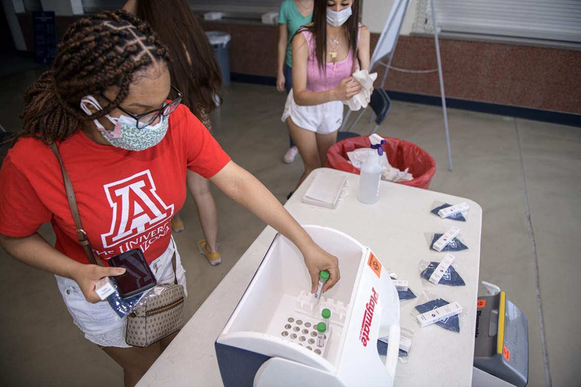 Students deposit their COVID-19 test sample into a cooler for storage at McKale Center in Tucson. 