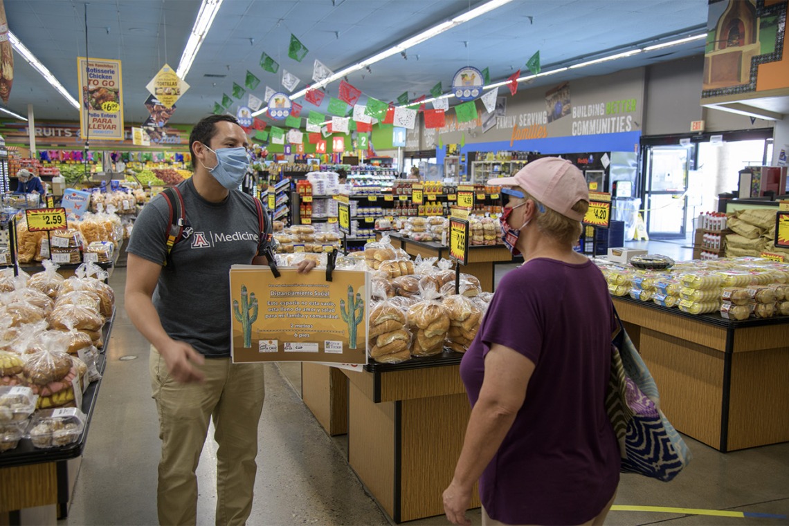 Fourth-year medical student Ricardo Reyes speaks with a customer at a Food City grocery store in Tucson about the social distancing campaign he and his classmates are hoping to share with the Spanish-speaking community.