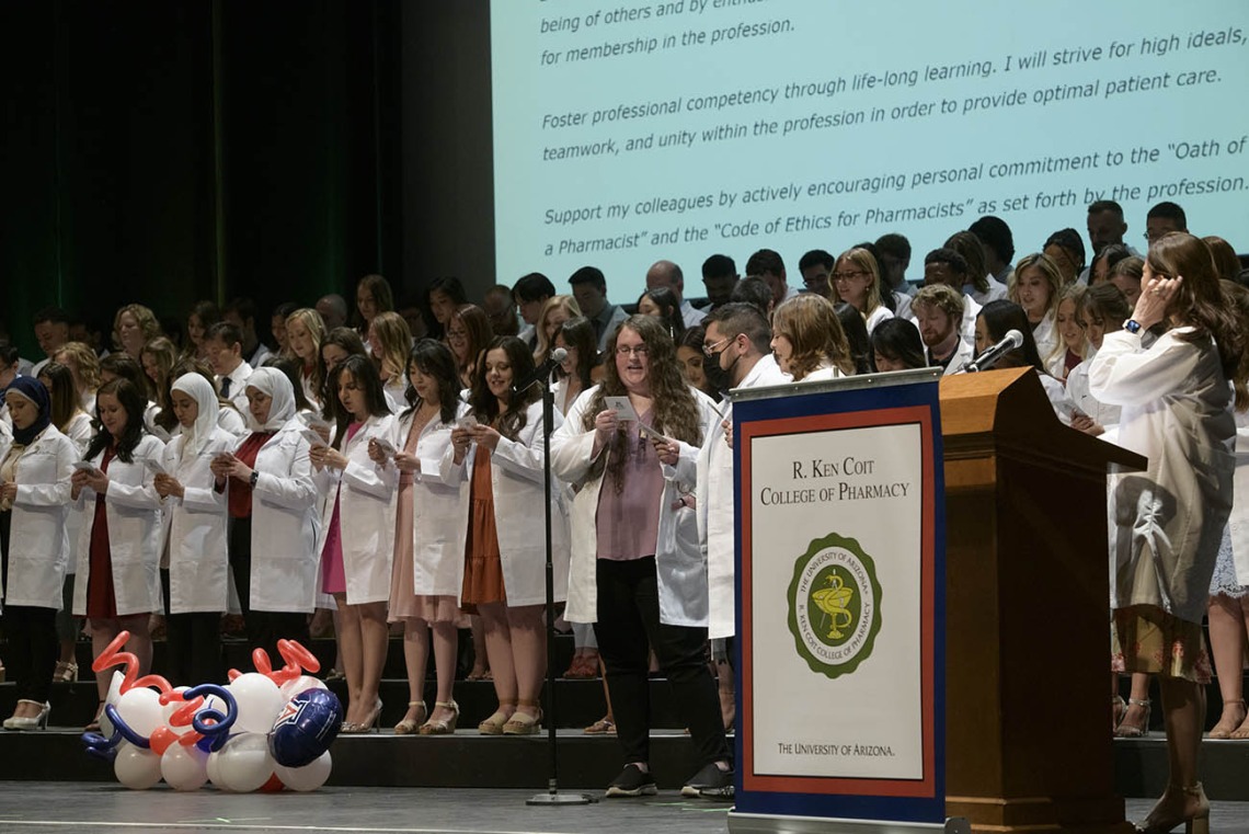 The R. Ken Coit College of Pharmacy class of 2023 recites the pledge of professionalism together after receiving their white coats during a ceremony at Centennial Hall. 