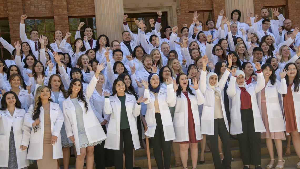The R. Ken Coit College of Pharmacy class of 2023 cheers as they prepare to have their class photo taken after their white coat ceremony at Centennial Hall. 