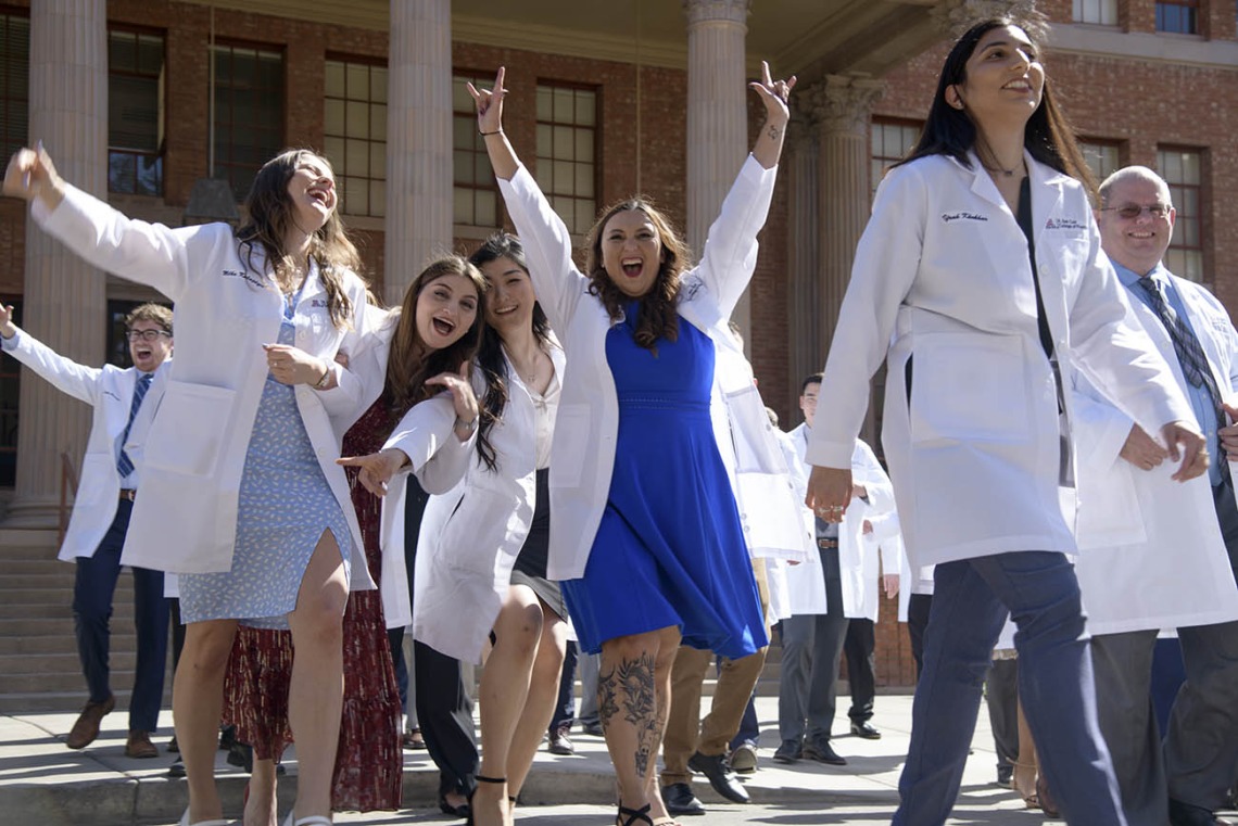 Jennifer Ramirez (center in blue) celebrates with her R. Ken Coit College of Pharmacy 2023 classmates after their white coat ceremony.