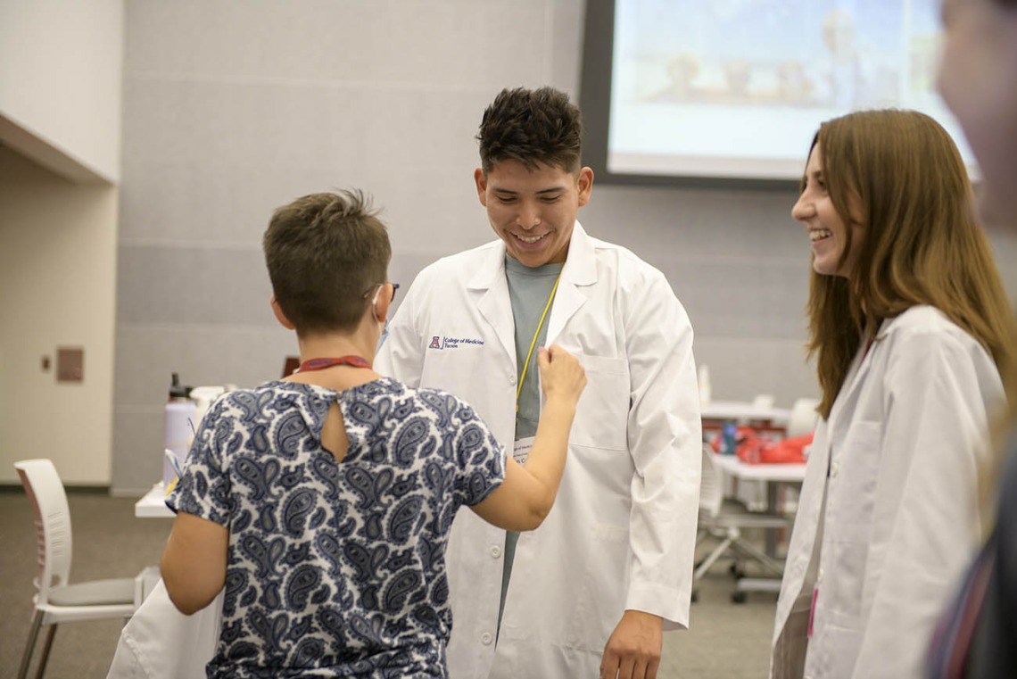 UArizona College of Medicine – Tucson first-year medical student Adam Carl gets fitted for his white coat inside the Health Sciences Innovation Building prior to the white coat ceremony. 