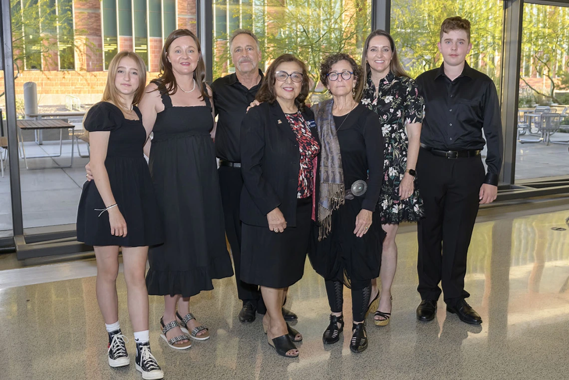 Six members of the Zuckerman family stand with Dr. Iman Hakim. 