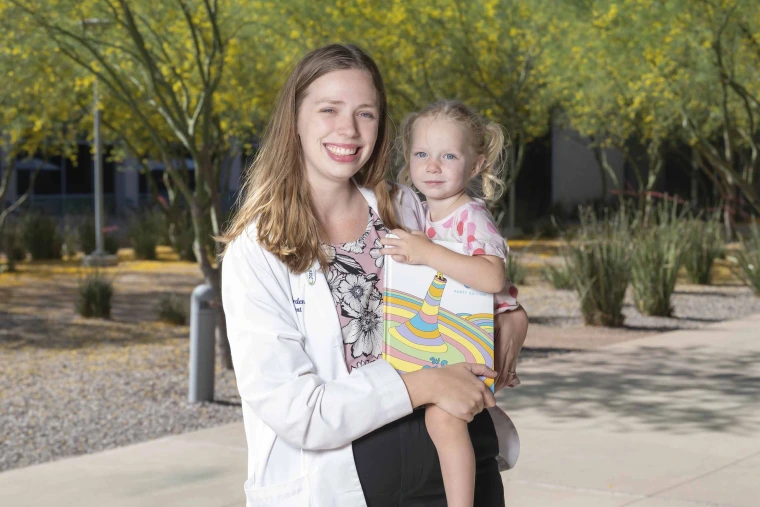 Elizabeth Borden, PhD, holding her 3-year-old daughter, Miriam
