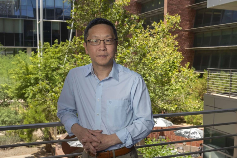 Portrait of Mingyu Liang, MB, PhD, standing outside in front of trees.