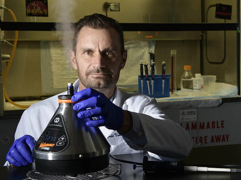 man sits behind lab bench