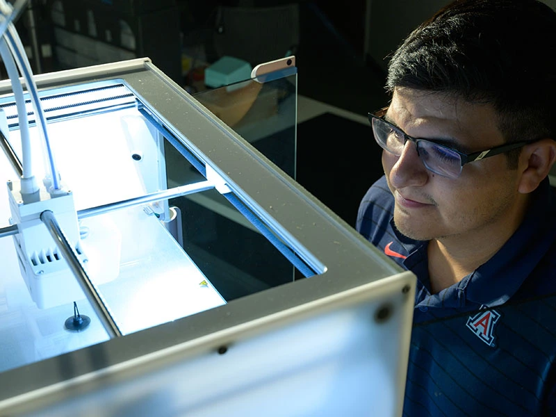 student watching 3D printer at work