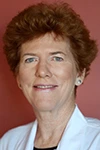 [Woman with red hair facing right and wearing a physician's white coat]