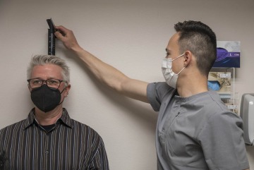 Victor Mendoza (right), a senior clinical research coordinator with the All of Us UArizona – Banner team, measures Gawain Douglas’s height as one of the many biostatistics collected for his All of Us profile. 