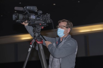 Jeffrey Homoki, BioCom information technology support center specialist, operates the camera at the College of Medicine – Tucson Class of 2024 White Coat Ceremony.