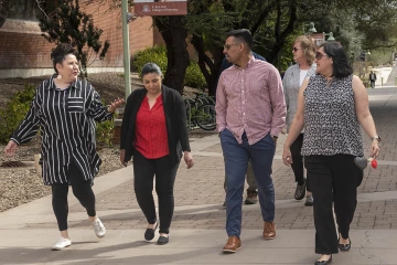 Three women and one man walking