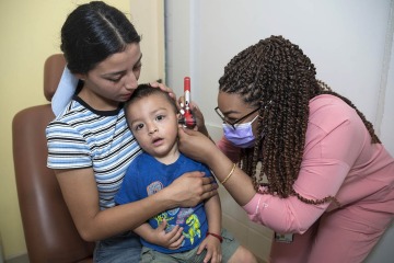 College of Medicine – Tucson student Leenda Osman checks a young patient’s ear at the Rocky Point Medical Centers in Puerto Penasco, Mexico. 