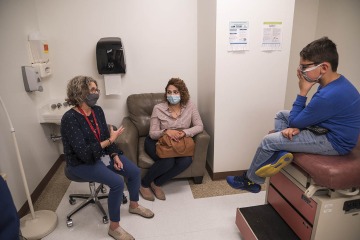 Patricia Lebensohn, MD (left), speaks with a mother and patient in the Shubitz Family Clinic, which is part of the College of Medicine – Tucson’s Commitment to Underserved People program.