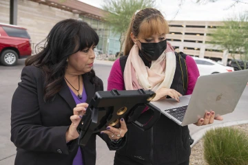 (From left) Alma Aguirre, program coordinator for Med-Start and Lopez prepare to livestream the Veterans Day flag raising ceremony. 