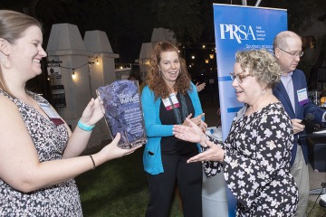 Caroline Berger (right), director of Phoenix corporate and community relations for Health Sciences, accepts the Best of Show award for the highest score among any type of communications and public relations for the Office of Communications’ Connect2STEM community engagement event. 