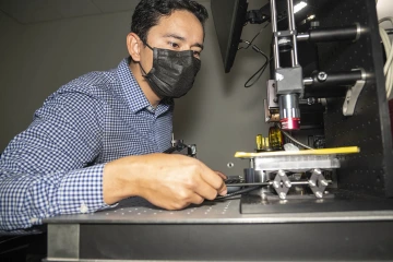 Natzem Lima performs hardware adjustments on an imaging system to measure biomarkers for esophageal cancer screening during the prototyping phase of the course.