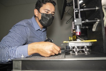 Natzem Lima performs hardware adjustments on an imaging system to measure biomarkers for esophageal cancer screening during the prototyping phase of the course.