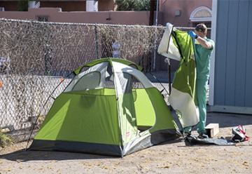 Chris Vance helps set up a tent at the Z Mansion in downtown Tucson where homeless individuals with potential or suspected coronavirus infection can be isolated and cared for by UArizona medical students.  